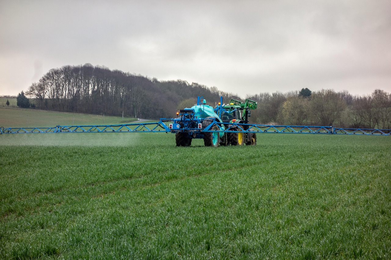 tractor spraying fertilizer on field